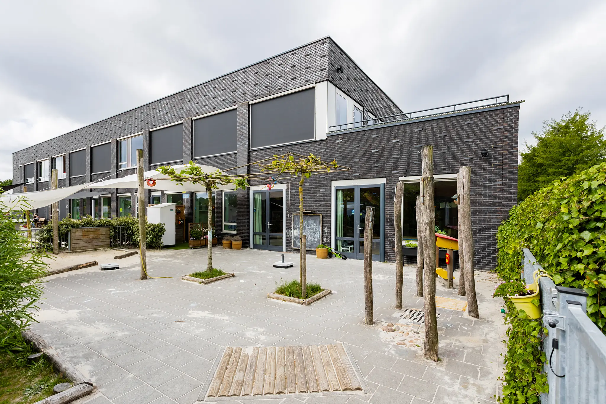 Woelwaters II achterkant gebouw Overzicht van tuin KDV Woelwaters II bij CKC De Rietzanger